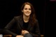 A woman sitting in a chair smiling at the camera.