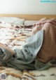 A person laying on a bed covered in a blanket.